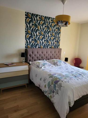 um quarto com uma cama e uma mesa com um candeeiro em Bel appartement à Rueil-Malmaison em Rueil-Malmaison