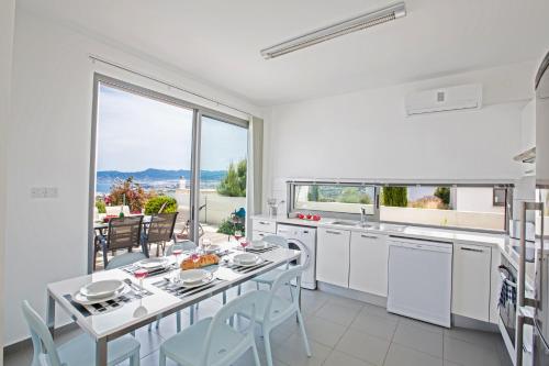 a kitchen with a table and chairs and a large window at Jenny Villa 23 in Polis Chrysochous
