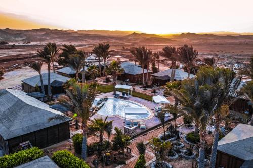 an aerial view of a resort with a pool and palm trees at Abu Dabbab Lodge in Abu Dabab