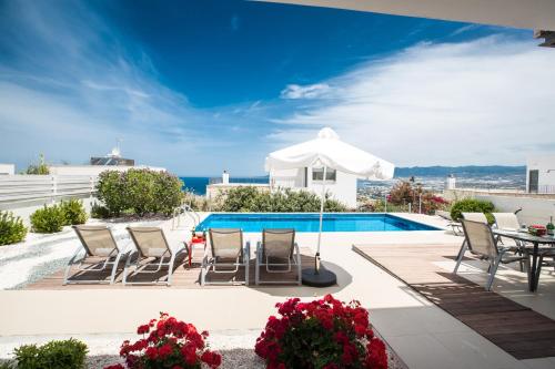 a pool with chairs and a table and an umbrella at Jenny Villa 23 in Polis Chrysochous