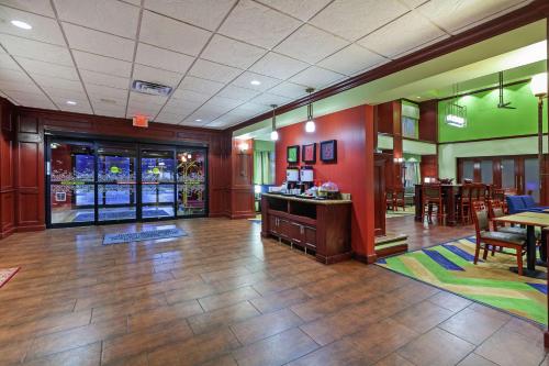 a lobby with a restaurant with tables and chairs at Hampton Inn & Suites Owasso in Owasso