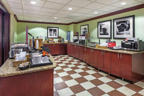 a kitchen with wooden cabinets and a checkered floor at Hampton Inn & Suites Owasso in Owasso
