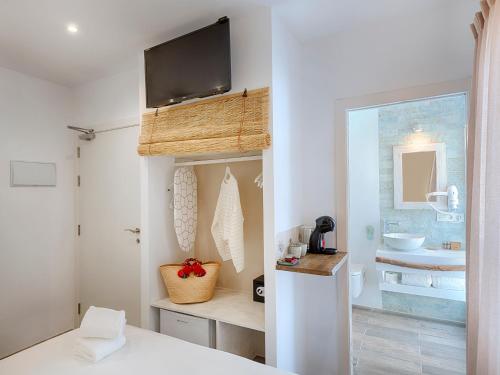 ein Schlafzimmer mit einem Bett und ein Badezimmer mit einem Waschbecken in der Unterkunft Hostal Perla Blanca Altea in Altea