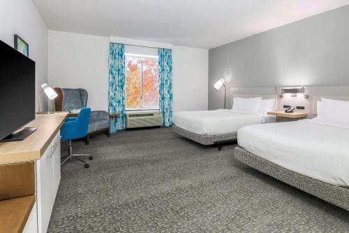a hotel room with two beds and a desk at Hilton Garden Inn Tulsa South in Tulsa