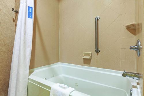 a bathroom with a bath tub with a shower curtain at Hampton Inn & Suites Owasso in Owasso