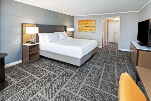 a hotel room with a bed and a flat screen tv at DoubleTree by Hilton Tulsa - Warren Place in Tulsa