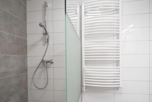 a bathroom with a shower with white tiles at Stylish NEW home with view on New York Palace in Budapest