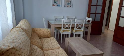 a living room with a couch and a table and chairs at Apartamento Sevilla 3 in La Guardia