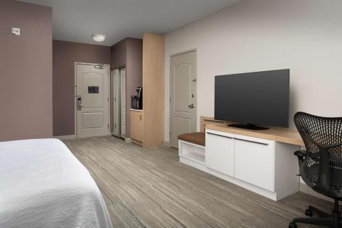 a hotel room with a bed and a flat screen tv at Hilton Garden Inn Knoxville West/Cedar Bluff in Knoxville