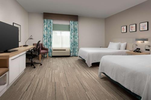 Habitación de hotel con 2 camas, escritorio y TV. en Hilton Garden Inn Knoxville West/Cedar Bluff, en Knoxville