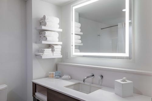 bagno bianco con lavandino e specchio di Hampton Inn & Suites Knoxville-Downtown a Knoxville