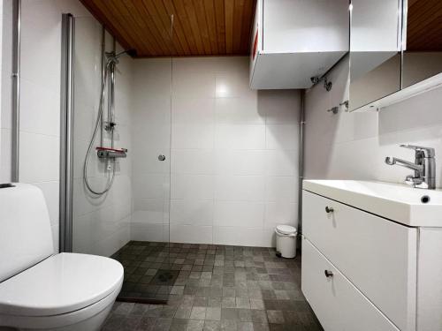 a bathroom with a toilet and a sink and a shower at Transit Apartment HEL Airport in Vantaa