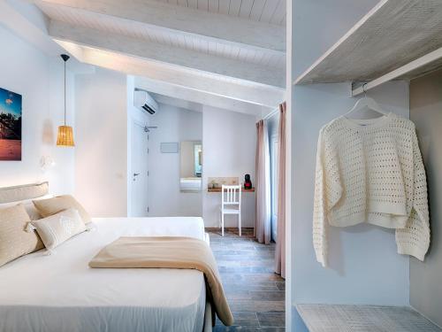 a bedroom with a bed and a sweater hanging on a wall at Hostal Perla Blanca Altea in Altea