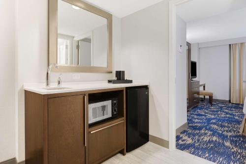 a bathroom with a sink and a microwave at Embassy Suites by Hilton Alexandria Old Town in Alexandria