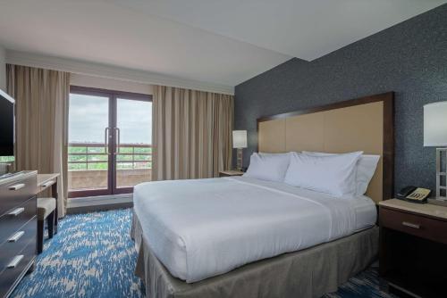 a hotel room with a bed and a television at Embassy Suites by Hilton Alexandria Old Town in Alexandria