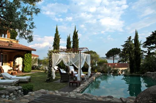 a backyard pool with a gazebo next to a house at La Criolda Charming Villa in San Felice del Benaco