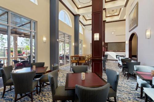 a restaurant with tables and chairs and windows at Hampton Inn & Suites Wellington in Wellington