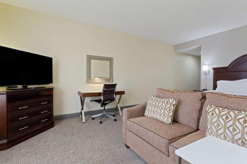 a hotel room with a couch and a desk at Hampton Inn & Suites Wellington in Wellington