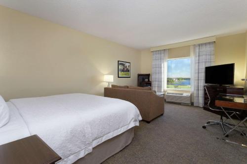 a hotel room with a bed and a television at Hampton Inn & Suites Wellington in Wellington