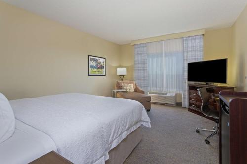 a hotel room with a bed and a flat screen tv at Hampton Inn & Suites Wellington in Wellington