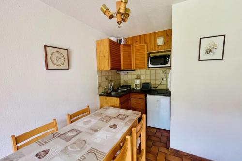 - une cuisine avec une table et deux chaises dans l'établissement 30 m next to Les Grands Bains, au Monêtier-les-Bains