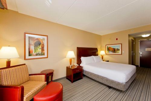 une chambre d'hôtel avec un lit et une chaise dans l'établissement Hilton Garden Inn Winchester, à Winchester