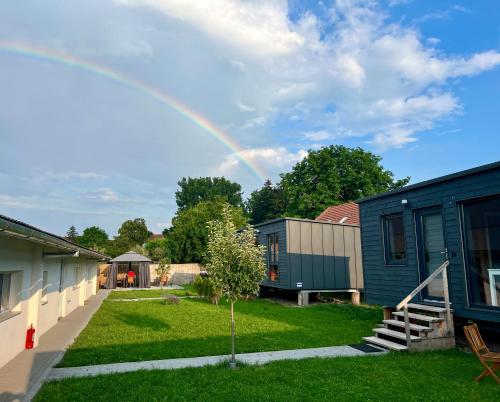 a rainbow in the sky over a yard at Pixel - Tiny Campus in Tîrgu Secuiesc