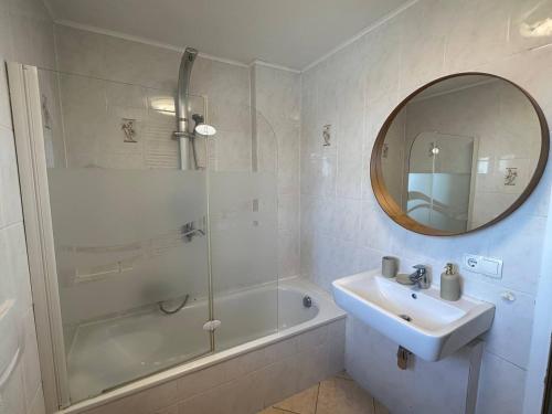 bagno con lavandino, vasca e specchio di Traumhaftes Zuhause! a Forstinning