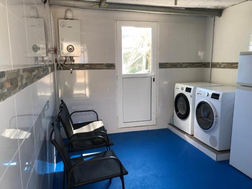 een wasruimte met een wasmachine, een wasmachine en een droger bij CASA MAR DE LUNA Playas en Raxo in Raxo