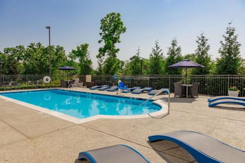 a swimming pool with lounge chairs and an umbrella at Hampton Inn Winchester in Winchester