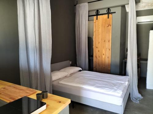 Bett in einem Zimmer mit Vorhängen und einem Tisch in der Unterkunft Casale Orgogliosa in San Vito Chietino