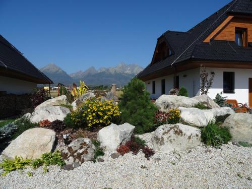 a garden with rocks and flowers in front of a house at Pinus Cembra in Stará Lesná