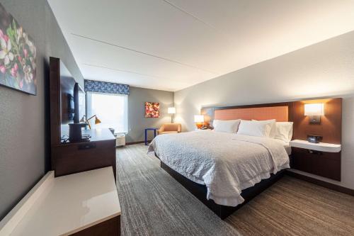 a hotel room with a bed and a television at Hampton Inn Winchester in Winchester