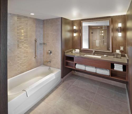 W łazience znajduje się wanna, umywalka i lustro. w obiekcie DoubleTree by Hilton West Edmonton w mieście Edmonton