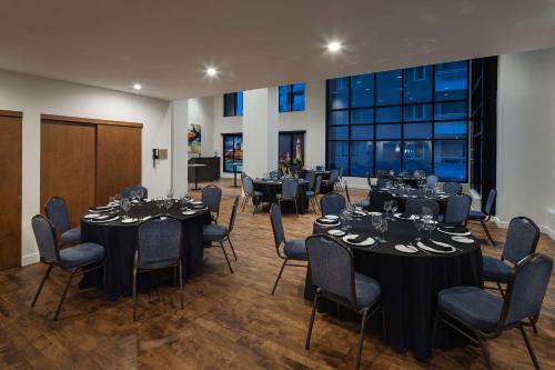 a room with tables and chairs and a large window at Hilton Garden Inn Montreal Centre-Ville in Montréal
