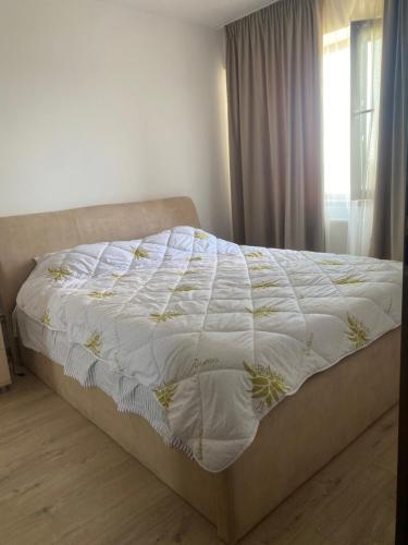 - un lit avec une couette blanche dans une chambre dans l'établissement Alexandra, à Piteşti