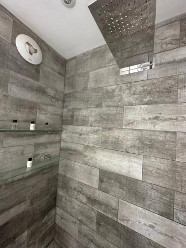 La salle de bains est pourvue d'une grande douche avec du carrelage en bois. dans l'établissement Pevensey Bay Villa, à Pevensey