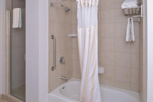a bathroom with a tub and a shower with a shower curtain at Hilton Garden Inn Yuma Pivot Point in Yuma