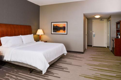 a hotel room with a large bed and a hallway at Hilton Garden Inn Yuma Pivot Point in Yuma