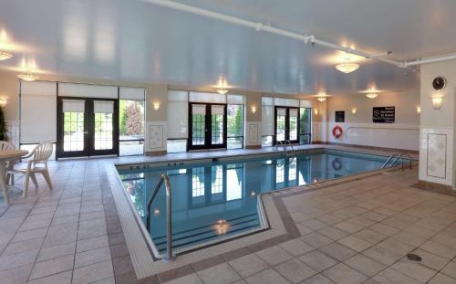 a large swimming pool in a building with a pool at Hampton Inn & Suites Laval in Laval