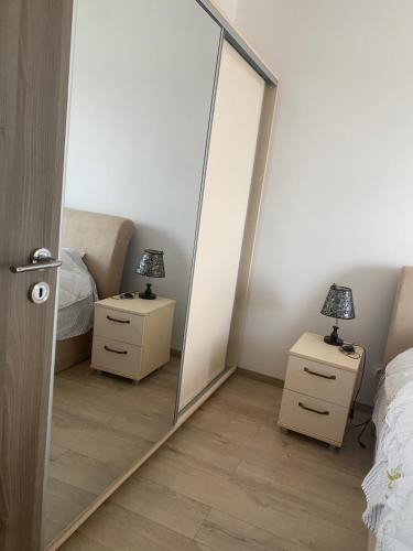un miroir dans une chambre avec deux tables de nuit et deux lampes dans l'établissement Alexandra, à Piteşti