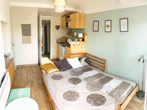 a bedroom with a large bed and a kitchen at Le dindouleto in Peynier