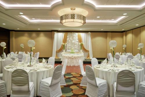 a banquet hall with white tables and chairs and a chandelier at Hilton Garden Inn Toronto Airport West/Mississauga in Mississauga