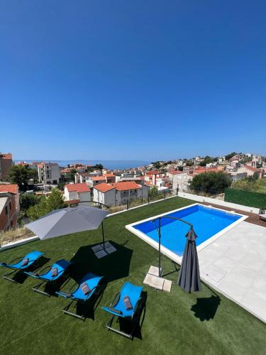 a group of chairs sitting next to a swimming pool at Villa La Vie - Podstrana in Podstrana
