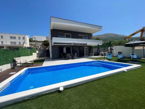 Villa con piscina frente a una casa en Villa La Vie - peacefull oasis with pool en Podstrana