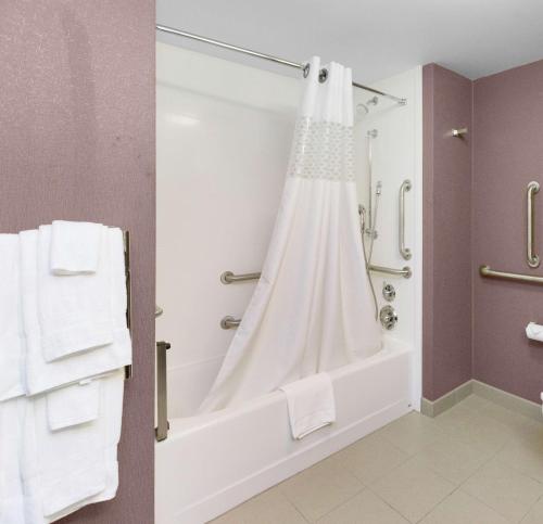 a bathroom with a tub and a shower with towels at Hampton Inn Butler in Butler