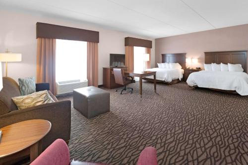 une chambre d'hôtel avec deux lits et un salon dans l'établissement Hampton Inn Butler, à Butler