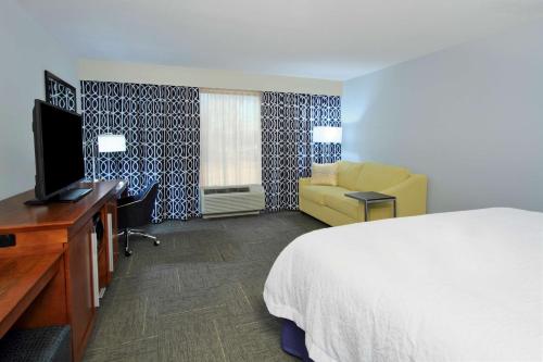 a hotel room with a bed and a television at Hampton Inn Richland/South Jackson in Richland