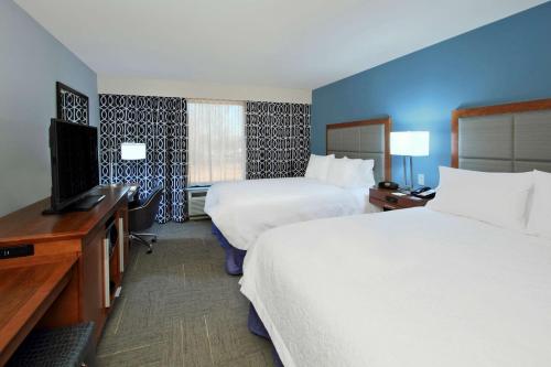 a hotel room with two beds and a flat screen tv at Hampton Inn Richland/South Jackson in Richland