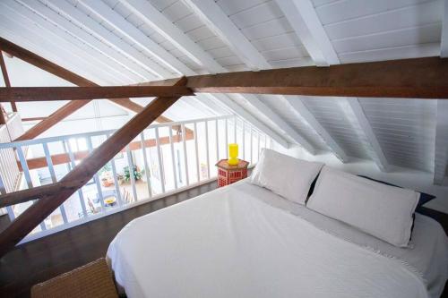 a bedroom with a white bed in a attic at Casa na Curva - Artists Corner Country house in Lagos